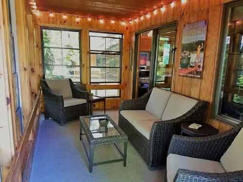 Una sala de estar con sillas, un sofá y una mesa. en Inviting Lakefront Cabin with a Private Dock in Boulder Junction, Wisconsin, en Boulder Junction