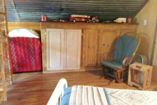 ein Schlafzimmer mit einem Bett, einer Couch und einem Sessel in der Unterkunft Rustic Two-Bedroom Cabin Rental on Hamilton Creek in Texas Hill Country in Marble Falls