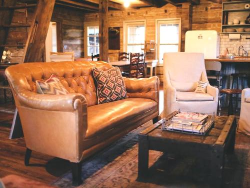 a leather couch and a chair in a living room at Gorgeous Country Cottage for a Farm Getaway in Cookeville, Tennessee in Cookeville