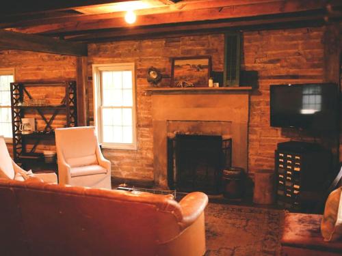 a living room with a couch and a fireplace at Gorgeous Country Cottage for a Farm Getaway in Cookeville, Tennessee in Cookeville