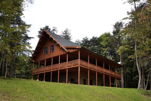 a large wooden house on top of a hill at Rustic Fishing Lodge Rental with a Spacious Deck in Logan, Ohio in Cedar Grove