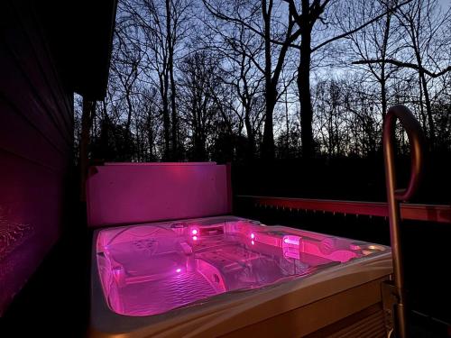 a pink lighted box sitting on a balcony at Chic Modern Cabin with Jacuzzi Ideal for Couples in Carbondale, Illinois in Makanda