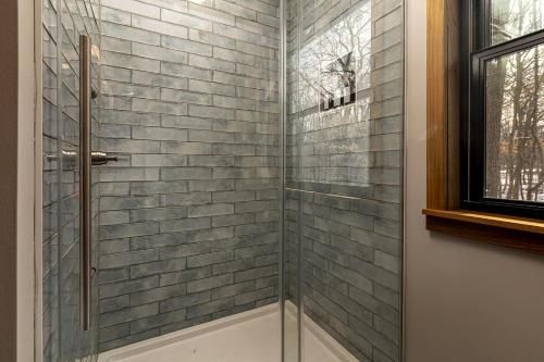 a shower with a glass door in a bathroom at Chic Modern Cabin with Jacuzzi Ideal for Couples in Carbondale, Illinois in Makanda