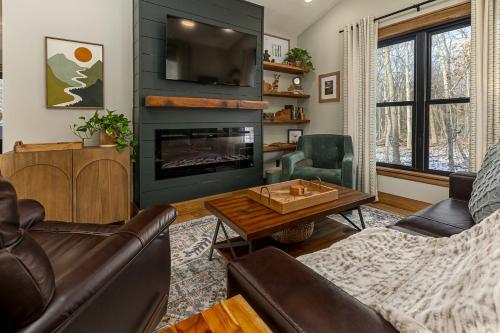 a living room with a couch and a fireplace at Chic Modern Cabin with Jacuzzi Ideal for Couples in Carbondale, Illinois in Makanda