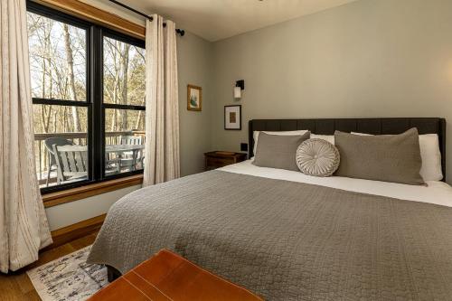 a bedroom with a large bed and a large window at Chic Modern Cabin with Jacuzzi Ideal for Couples in Carbondale, Illinois in Makanda