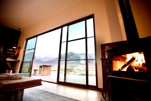 a living room with a fireplace and a large glass door at Luxury Design Rental with Breathtaking Mountain Views in Lone Pine, California in Lone Pine