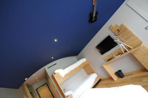 a bedroom with blue walls and a bed with white sheets at Logis Hotel Restaurant Au Boeuf Rouge in Niederschaeffolsheim