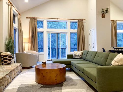 ein Wohnzimmer mit einer grünen Couch und einem Tisch in der Unterkunft Enchanting Creekside Cabin Retreat near Yosemite National Park in California in Fish Camp