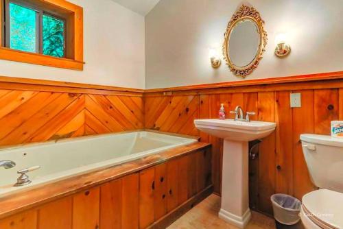 卡纳登西斯Traditional Wooden Cabin Rental in the Poconos, Pennsylvania的带浴缸、水槽和马桶的浴室