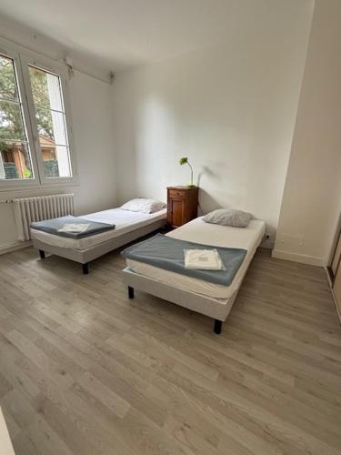 a room with two beds and a window at Hebergements le Camp d'Auneau - Leboudubout in Auneau