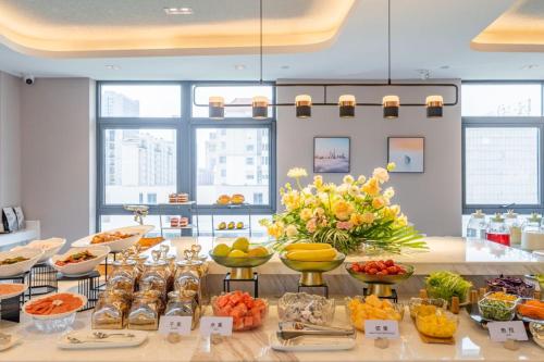 ein Buffet mit Obst und Gemüse auf dem Tisch in der Unterkunft Atour Hotel Wuxi Huishan Wanda Plaza in Wuxi