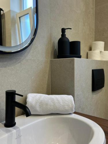 a bathroom sink with a faucet and a mirror at Apartamenty Centrum Chodzież in Chodzież