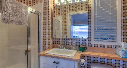 une salle de bain avec un lavabo, un miroir et une douche dans l'établissement Waterfront Cottage Rental with Spectacular Sunset Views on Orcas Island, Washington, à Deer Harbor