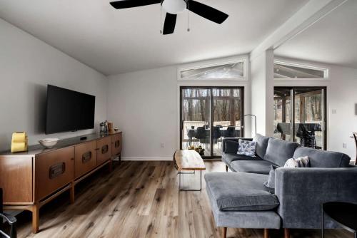 a living room with a couch and a flat screen tv at Enchanting Woodland Cabin Retreat near Cacapon River in West Virginia in Smith Crossroads