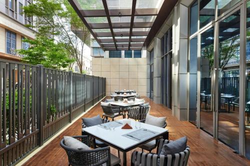 a patio with tables and chairs on a balcony at Four Points by Sheraton Shanghai International Tourism and Resorts Zone in Nanhui