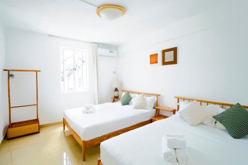a bedroom with two beds and a window at Grand Baie Family Residence in Grand Baie