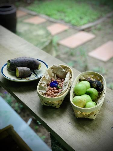 three baskets of fruits and vegetables on a table at Bến Tre Homestay in Ben Tre