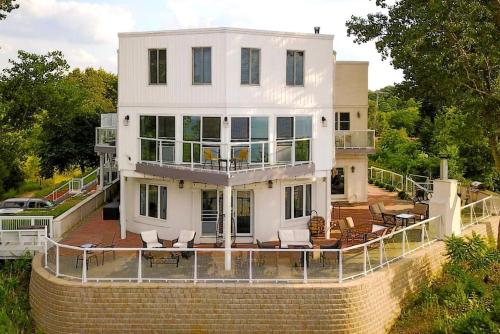 une grande maison blanche au sommet d'un mur de briques dans l'établissement Lakeside Villa with a Hot Tub and Amazing Views on Lake Michigan, Indiana, à Miller