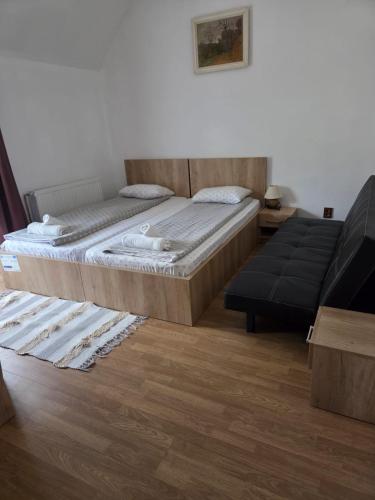 a bedroom with a bed and a couch at Pensiunea Gradia Șuncuiuș in Şuncuiuş