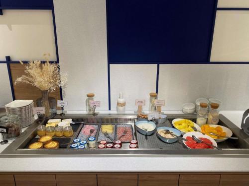 a kitchen counter with many different types of food at Mercure Rouen Val de Reuil in Val de Reuil