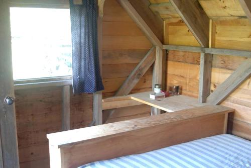 Habitación en el ático con cama y ventana en Romantic Getaway Cabin on a Working Farm in Royalton, Vermont, en South Royalton