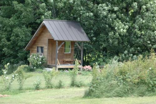una pequeña cabaña de madera en medio de un campo en Romantic Getaway Cabin on a Working Farm in Royalton, Vermont, en South Royalton