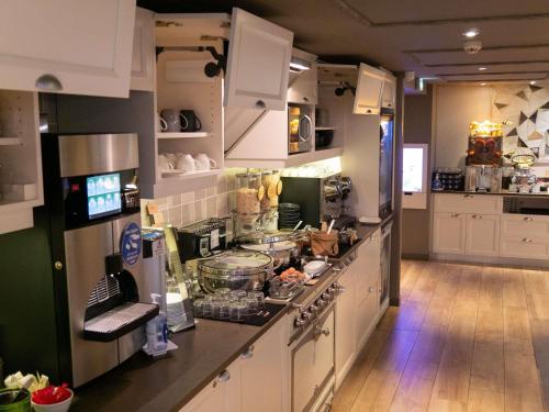 a kitchen with white cabinets and a counter top at Mercure Toulouse Centre Wilson Capitole in Toulouse