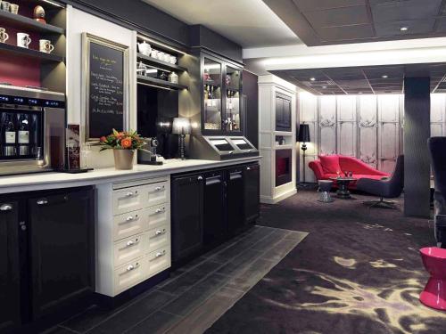 a wine bar with a red chair in a room at Mercure Toulouse Centre Wilson Capitole in Toulouse