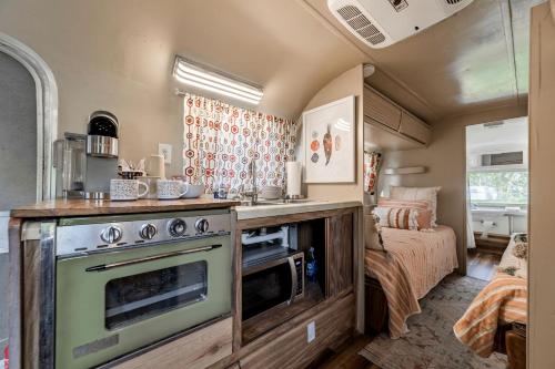a kitchen with a stove and a bed in a room at Newly Renovated Camper with Fresh Decor and Tiny Deck in Texas in Spicewood