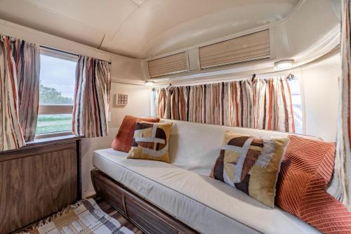 a couch in the back of an rv with pillows at Newly Renovated Camper with Fresh Decor and Tiny Deck in Texas in Spicewood