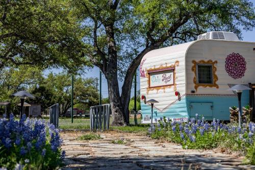 an old caravan is parked next to a tree at Newly Renovated Camper with Fresh Decor and Tiny Deck in Texas in Spicewood