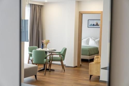 una habitación con una mesa y sillas y una cama en Blue Sky Apart-Hotel Batumi, en Batumi