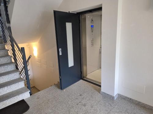 a door leading to a walk in shower next to a stairs at Residenza Erica in Moena