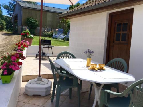 a white table and chairs on a patio at Gîte Margot in Vacqueriette