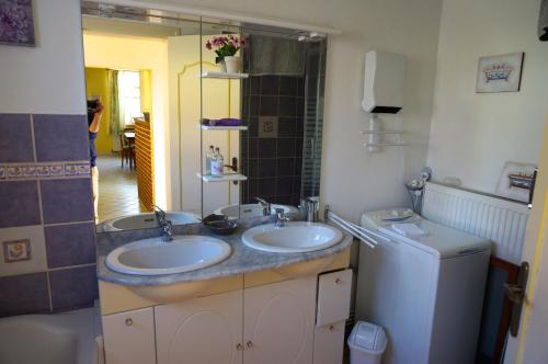 a bathroom with two sinks and a washing machine at Gîte Margot in Vacqueriette