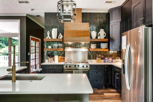 a kitchen with black cabinets and a stainless steel refrigerator at Stunning Rental with Hot-Tub, Theater Room and Great Landscape in Tennessee in Waldens Creek