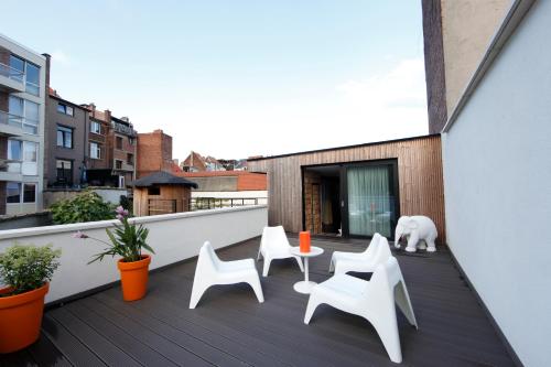 a balcony with white chairs and a white polar bear at Koto Garden Suites in Antwerp