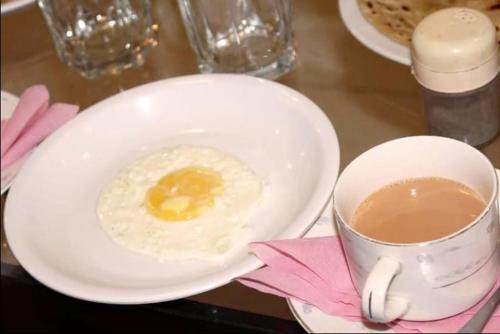 ein Spiegelei in einer Schüssel und eine Tasse Kaffee in der Unterkunft London lodges Guest House in Karatschi