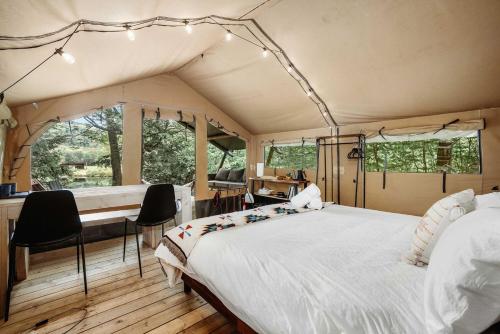 een slaapkamer in een tent met een bed en een bureau bij Magnificent Safari Tent with Sauna and Fire Pit in North Woodstock, New Hampshire in Woodstock