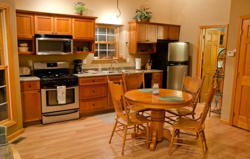 a kitchen with a wooden table and a table and chairs at Outstanding Cabin with Hot-tub in Carbondale, Illinois in Etherton