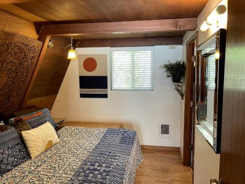 a small bedroom with a bed and a window at Gorgeous A-Frame by the Beach in Otter Rock, Oregon in Otter Rock
