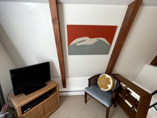 a living room with a tv and a chair at Gorgeous A-Frame by the Beach in Otter Rock, Oregon in Otter Rock