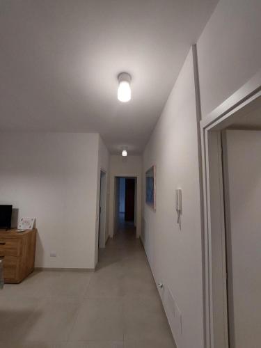 an empty hallway with a hallway leading to a room with a light at A window on San Bernardino in LʼAquila