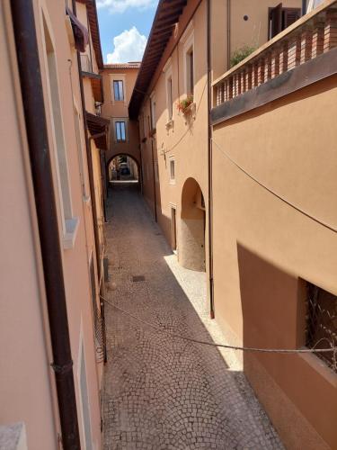an empty alleyway between two buildings in a city at A window on San Bernardino in LʼAquila