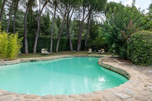 a pool with blue water in a yard at Apartament Monastero in Cortona