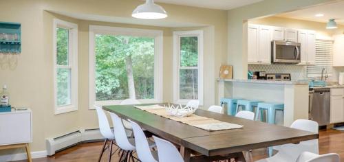 a kitchen with a wooden table and white chairs at Tranquil Lakefront Cottage with Private Dock in Ticonderoga, New York in Glenburnie