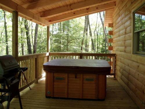 une véranda avec une table sur la terrasse. dans l'établissement Secluded Cabin Rental in the Forest near Beckley, West Virginia, à Hico