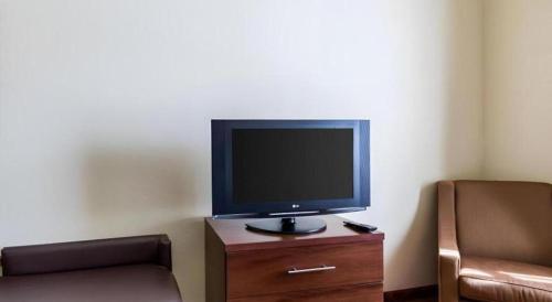 a tv sitting on a wooden dresser in a room at Comfort Suites near NASA - Clear Lake in Webster