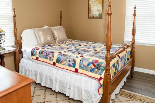 ein Schlafzimmer mit einem Bett mit einer Steppdecke darauf in der Unterkunft Elegant Cottage Rental for Groups near Greensburg, Kentucky in Columbia