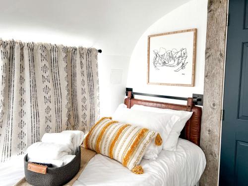 une chambre avec un lit avec des oreillers blancs dans l'établissement Sleek, Modern Airstream in Grand Junction, Ideal for Colorado Glamping Escapes, à Grand Junction